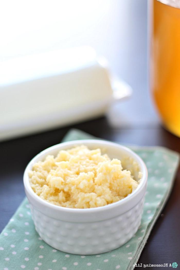 honey butter in a white dish on a green napkin with butter and honey behind it