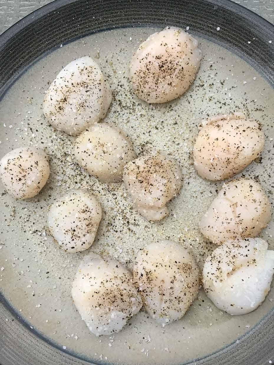 Scallops on plate ready to be grilled