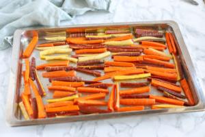 sliced carrots carefully placed onto baking sheet to bake into carrot fries