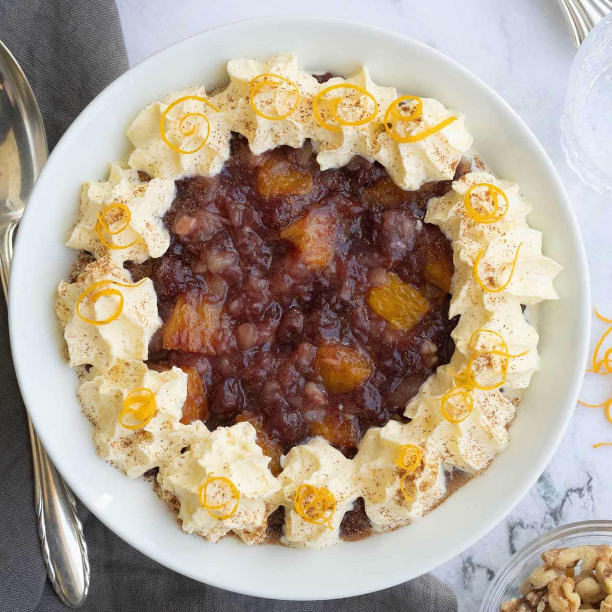 Cranberry salad toped with whipped cream and orange zest.