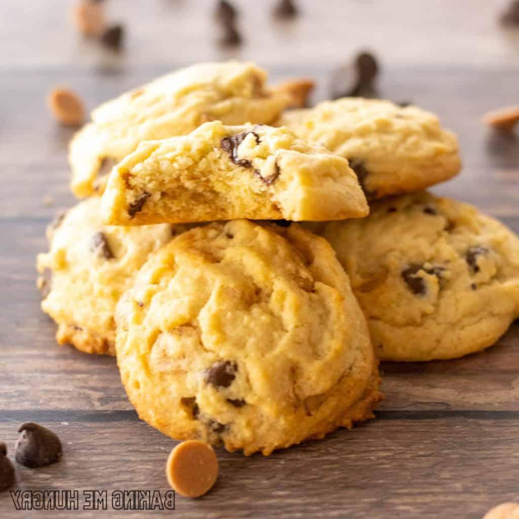 piled chocolate chip butterscotch cookies with one missing a bite